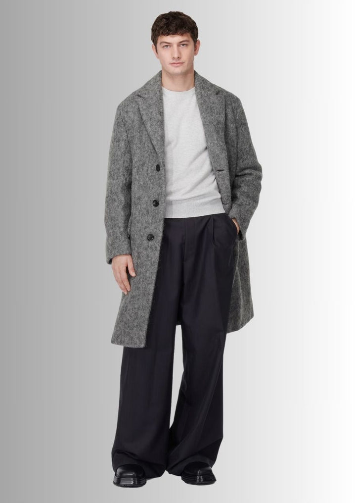 Manteau gris en laine pour homme, alliant modernité et confort.